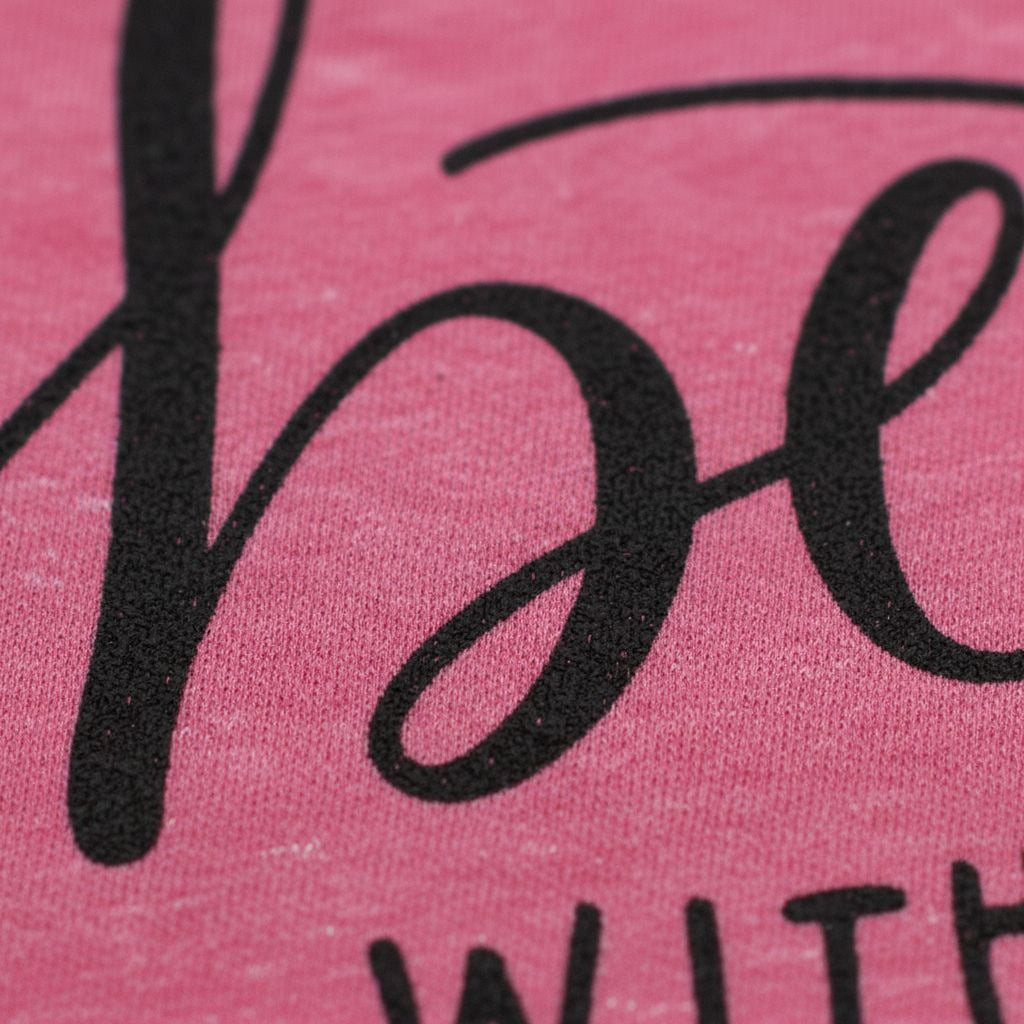Pink T-shirt close-up of “Life is better” script lettering and part of dog graphic