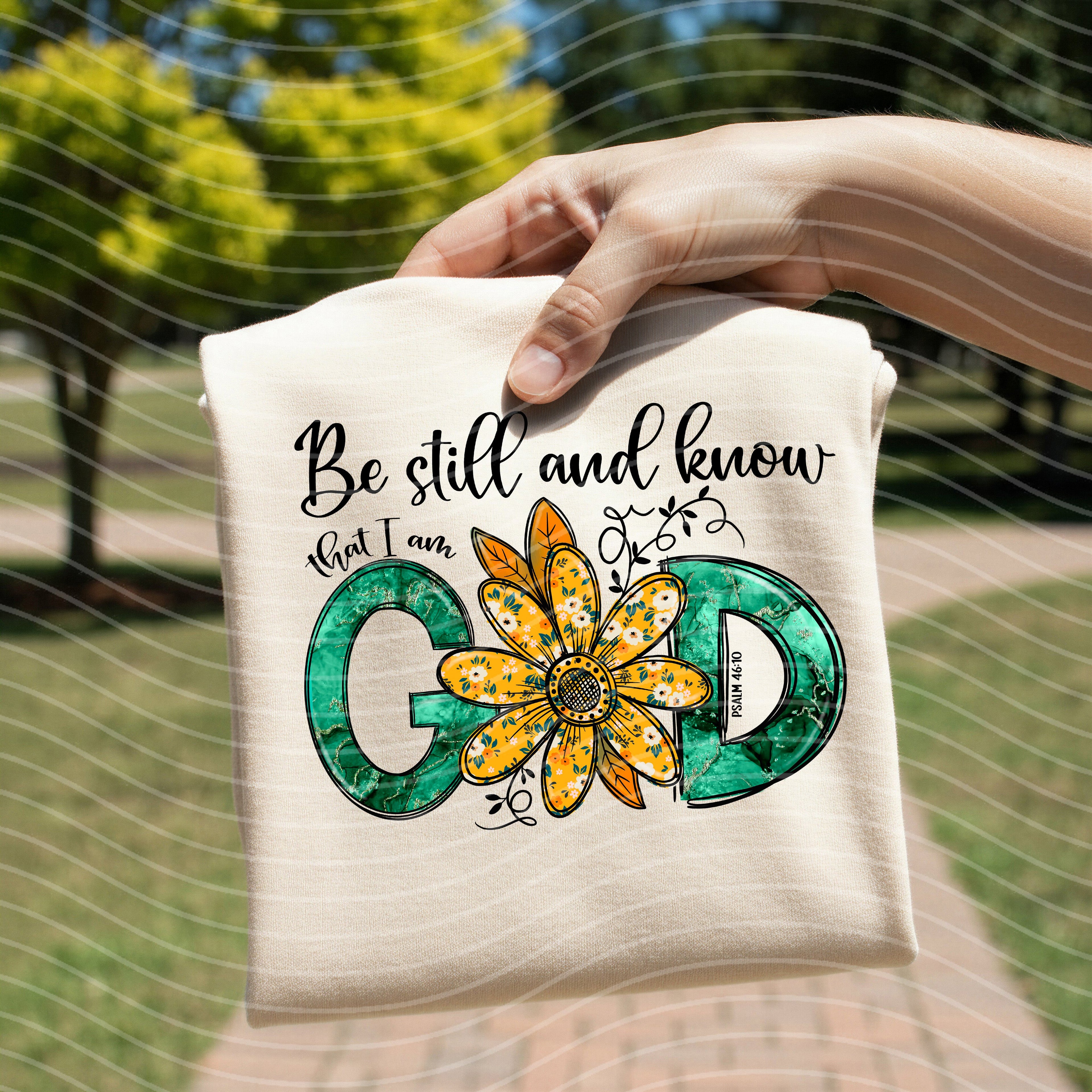 White graphic T-shirt with 'Be still and know' text and flower emblem