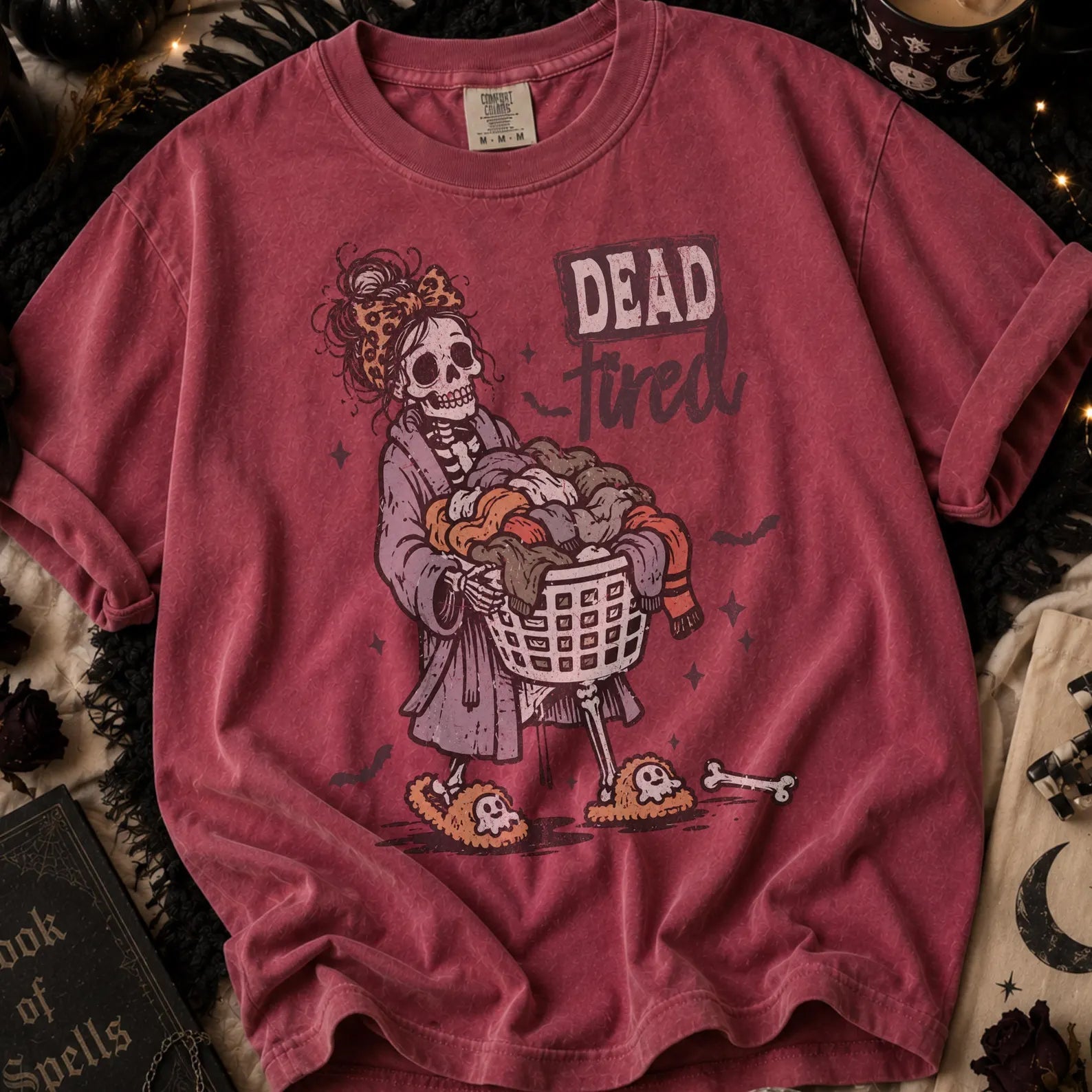 Burgundy graphic tee with skull holding TV remote and 'Dead' text