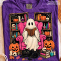 Purple graphic tee with ghost reading an open book, pumpkins and black cat.