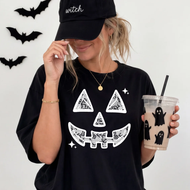 Black graphic tee with jack-o'-lantern face, bats, and stars