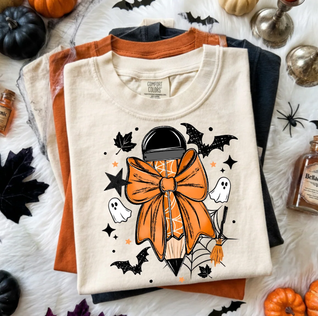 Cream graphic tee with jack-o'-lantern style character, bow, bats and stars