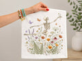 White graphic tee with dancing skeleton and colorful floral butterflies print