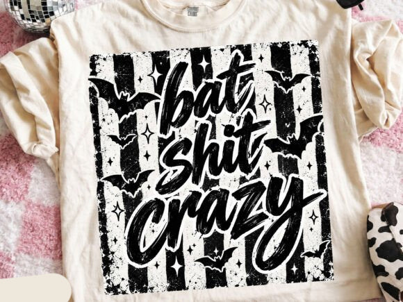 Bat-themed graphic tee with large black distressed text design on a light base