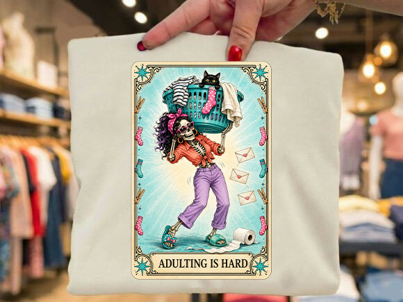 White graphic tee with colorful cartoon character and 'Adulting is Hard' print