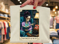 Graphic tee with framed illustration: woman reading by skull, phone and lamp, Booked & Busy