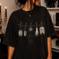 Black graphic T-shirt with Addams Family clothesline characters print