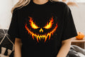 Black short-sleeve graphic tee with fiery pumpkin face illustration