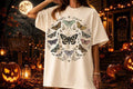 Light cream graphic tee with dark moths and a central butterfly-like design