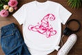 White graphic tee with pink witch-hat design and sparkles
