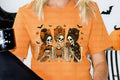 Orange graphic T-shirt with three skeleton girl faces and coffee-themed art