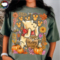 Dark green graphic T-shirt with cute bear holding honey, flowers and pumpkins