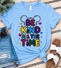 Light blue graphic T-shirt with 'BE KIND ALL THE TIME' colorful letters and hearts