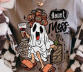 Light crewneck tee with cartoon ghost and 'Haunt Mess' graphic in orange and black