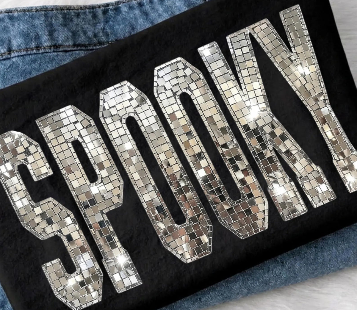 Black graphic tee with mirrored disco ball-style letter print on the front