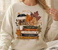White long-sleeve graphic tee with layered fall leaves and vintage reading quote print