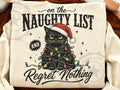 White graphic tee with 'Naughty List' text, cat in hat surrounded by lights