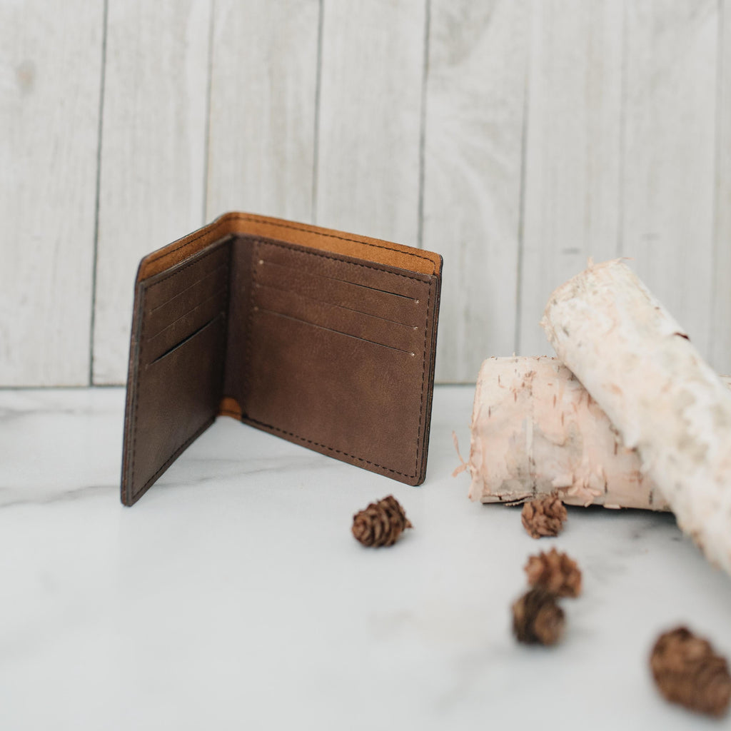 Brown leather slim bifold wallet open, showing interior card slots