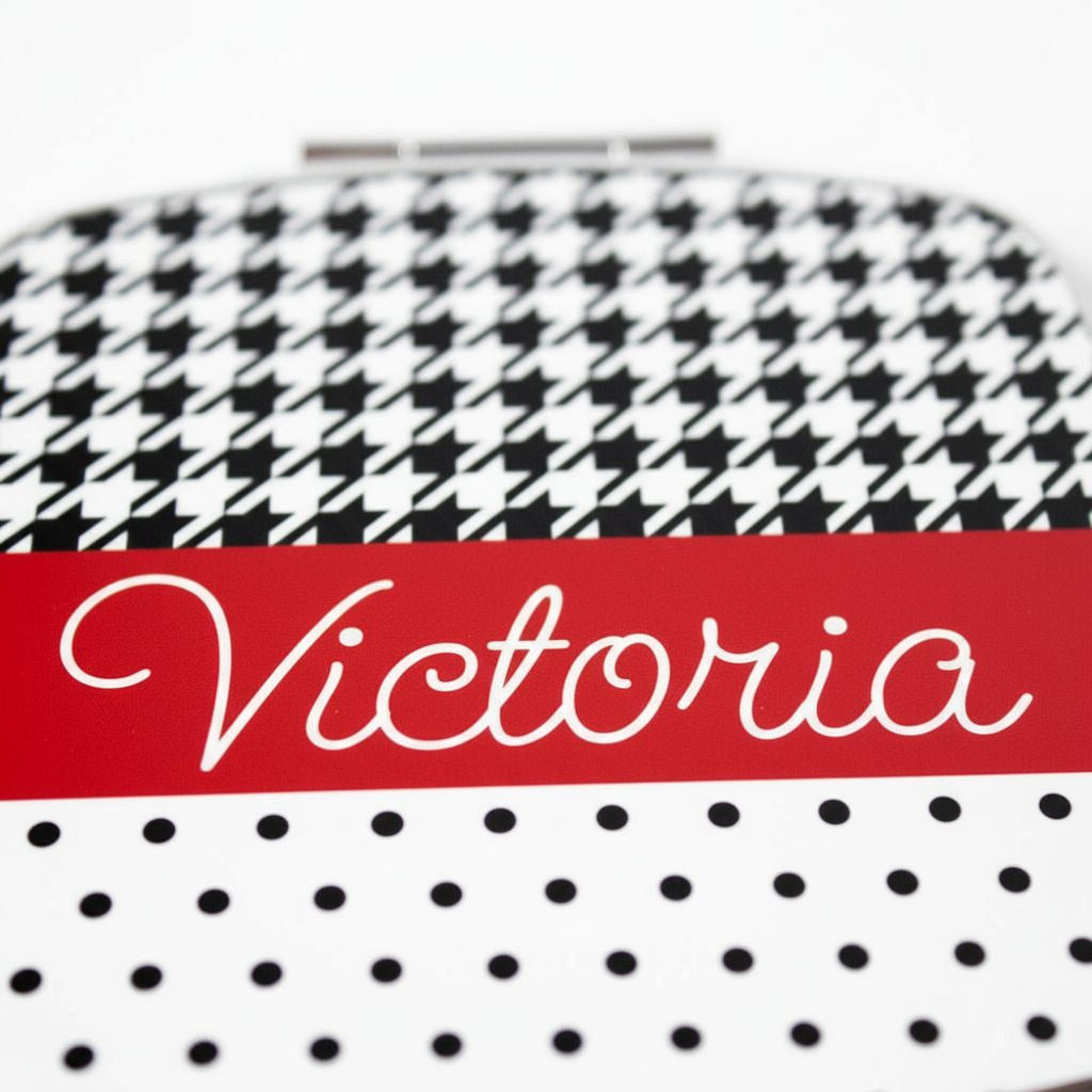 Personalized compact mirror closeup, red band with “Victoria” script over dot pattern