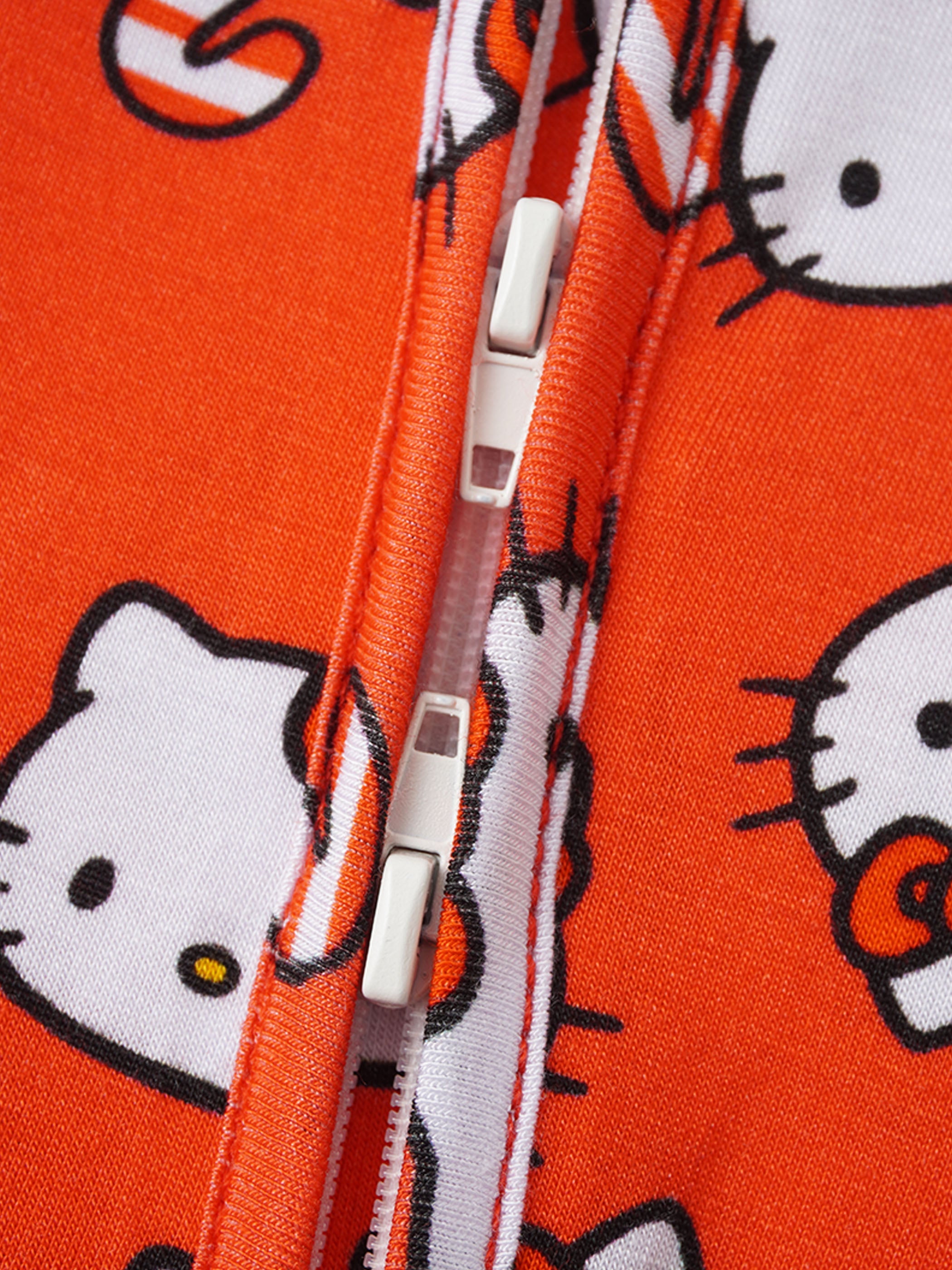 Red Hello Kitty romper front zipper close-up with white zipper pull