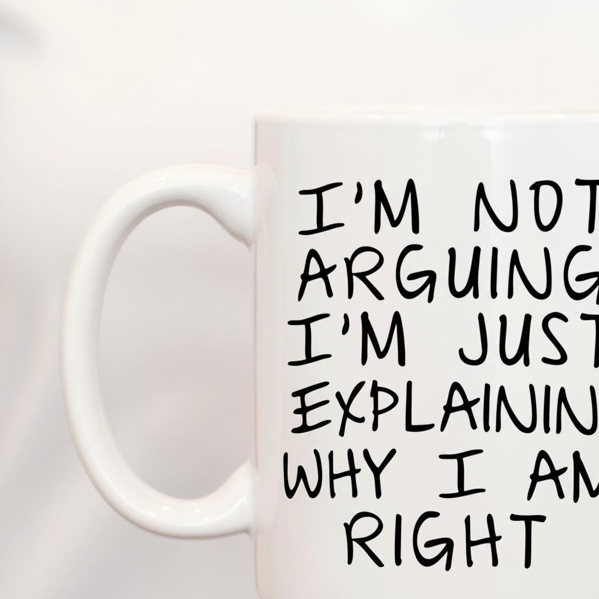 Close-up of white ceramic coffee mug with black quote text