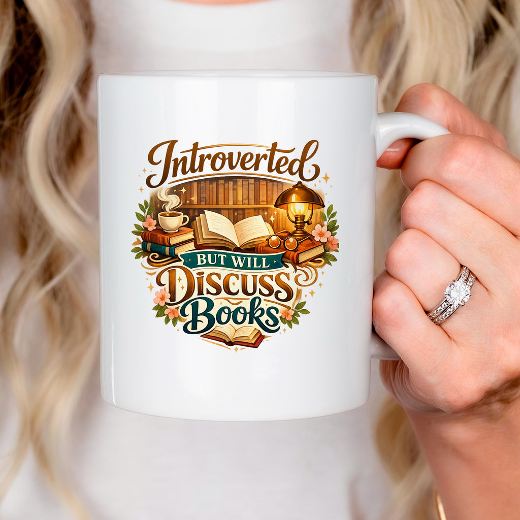 White ceramic mug held near face, with colorful "Introverted, but will discuss books" quote