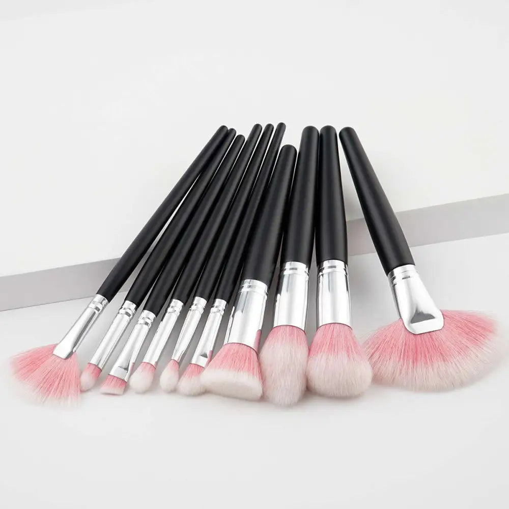 Makeup brush set with black handles and pink blush gradient bristles, fan layout