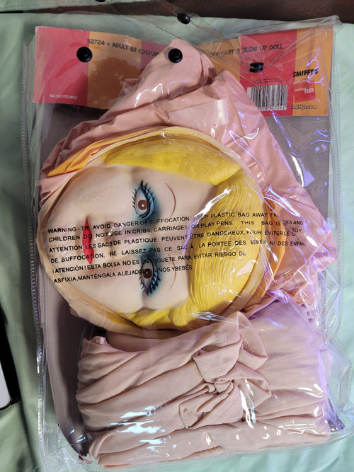 Inflatable blow-up doll head and beige bodysuit in plastic retail bag
