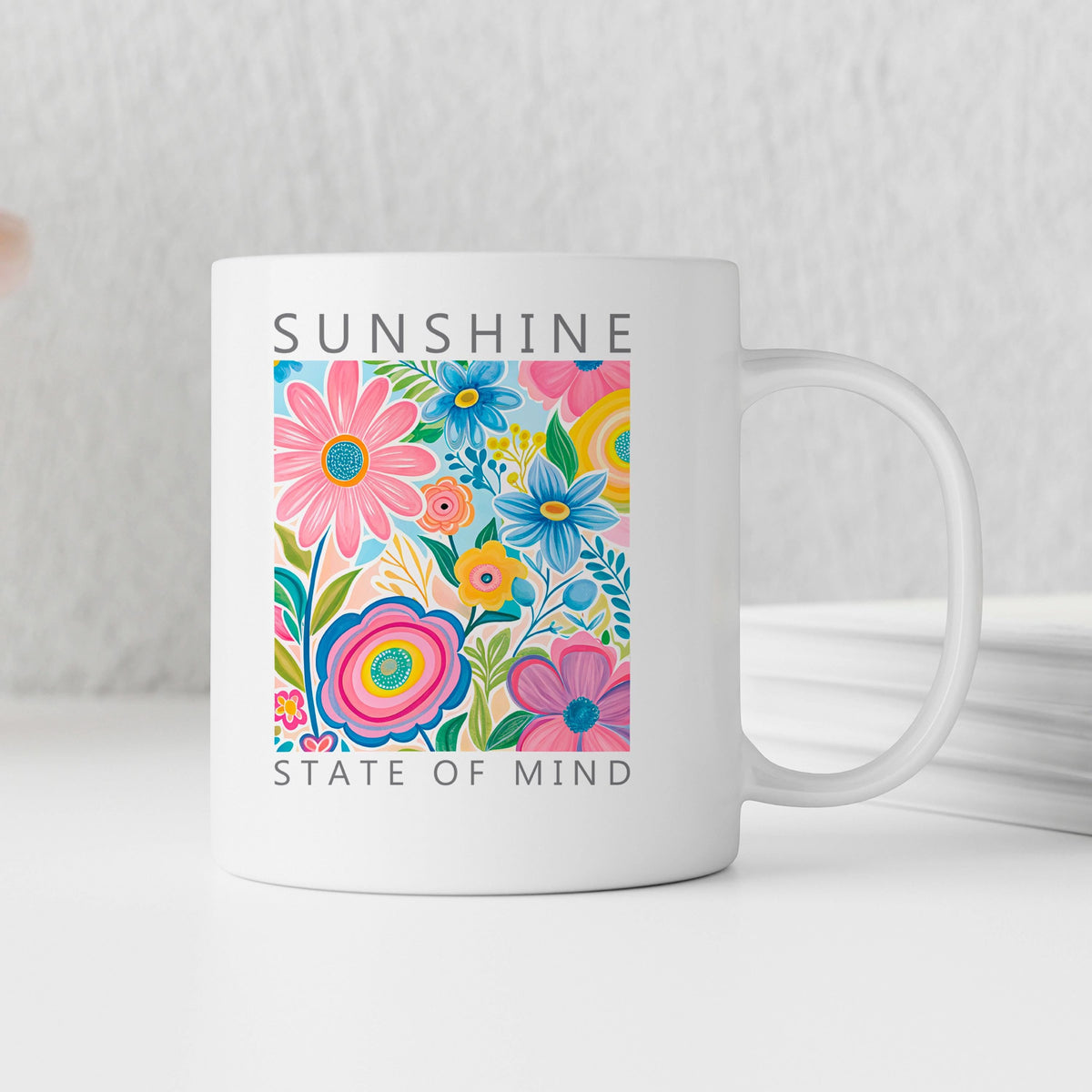 White ceramic coffee mug with colorful floral panel and “Sunshine State of Mind”.