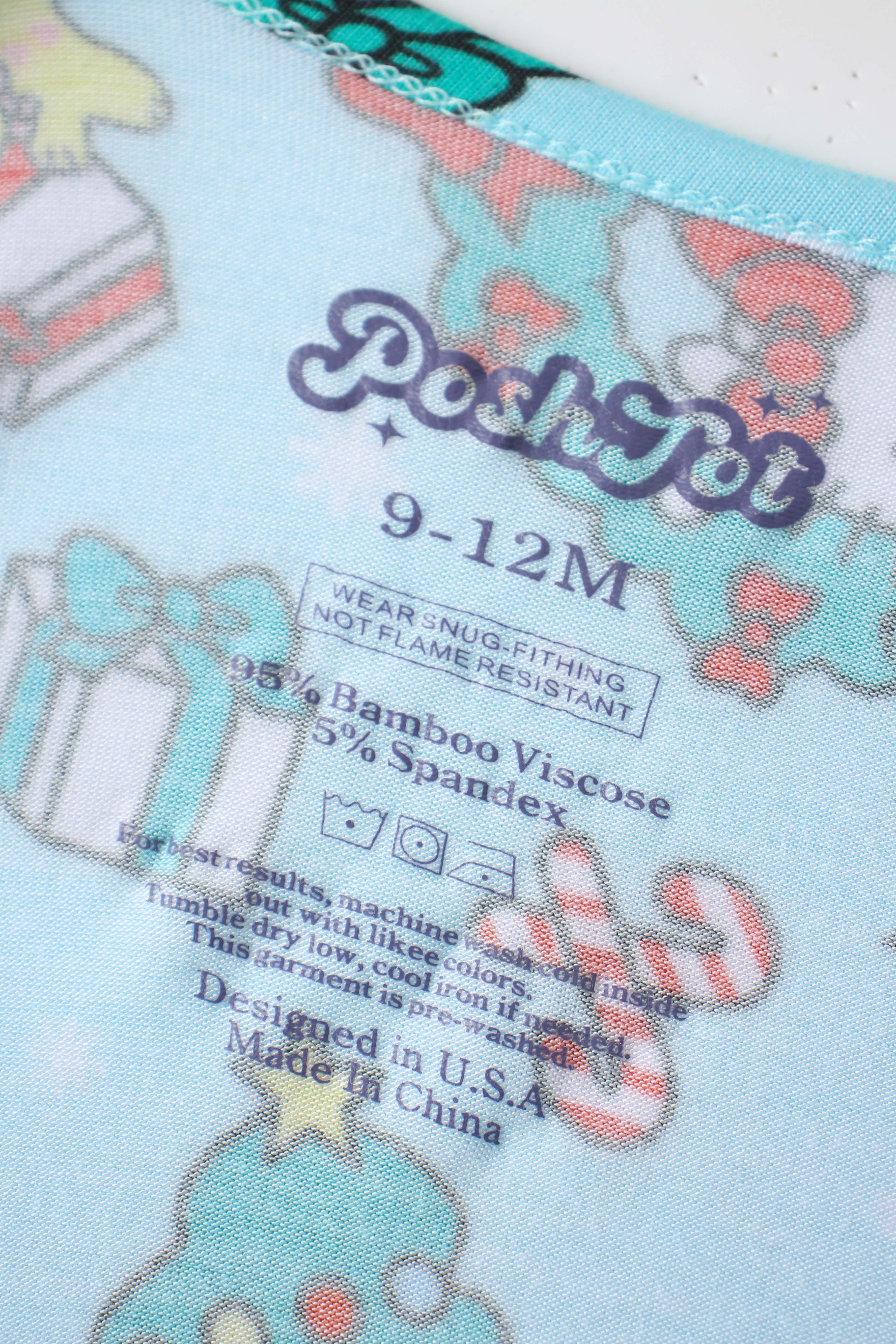 Baby romper fabric label area on light blue print, showing care and size text