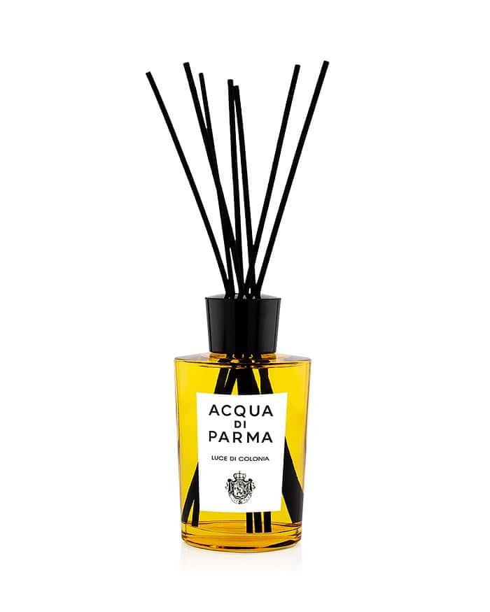 Room diffuser with amber glass bottle, black reed sticks, and branded label
