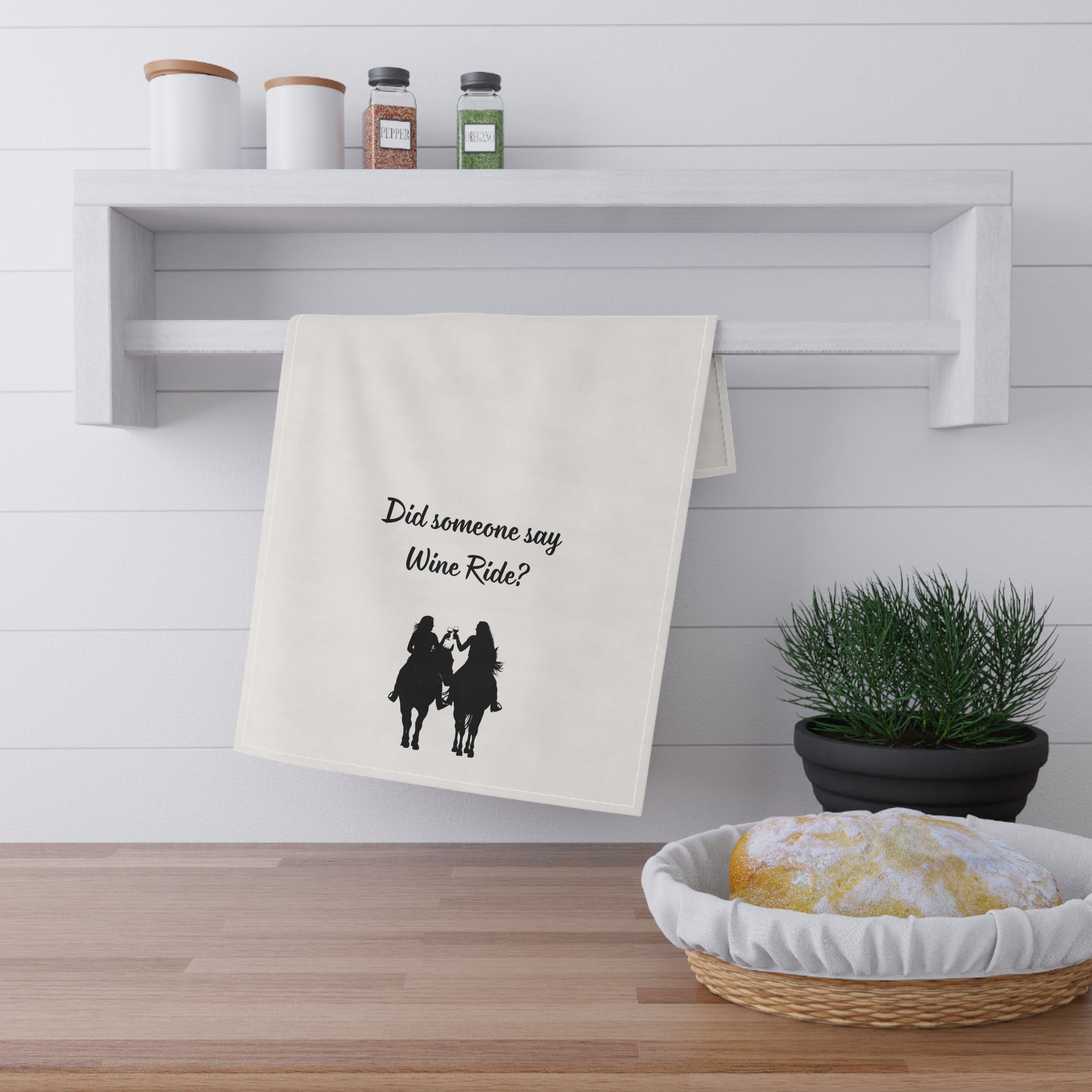 Folded wine-themed cowgirl tea towel on kitchen shelf, “Did someone say Wine Ride?”