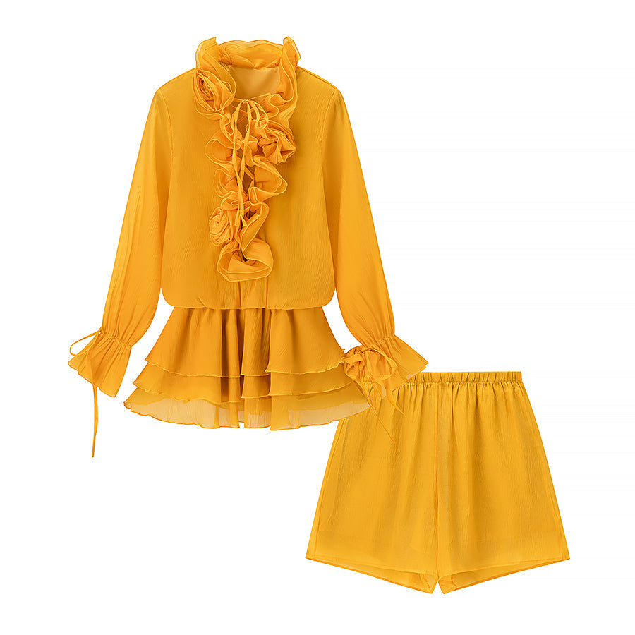 Mustard yellow ruffle blouse and matching shorts set on white background