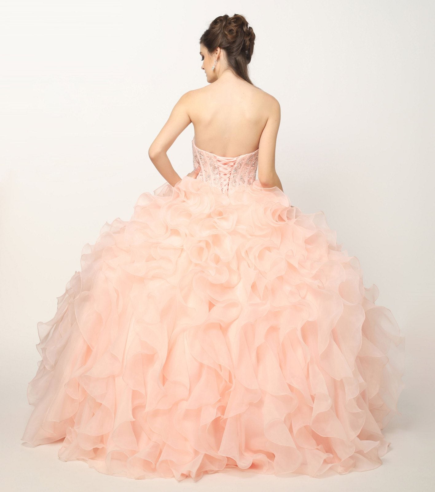 Light pink strapless ball gown with beaded corset bodice and layered organza ruffle skirt, back view