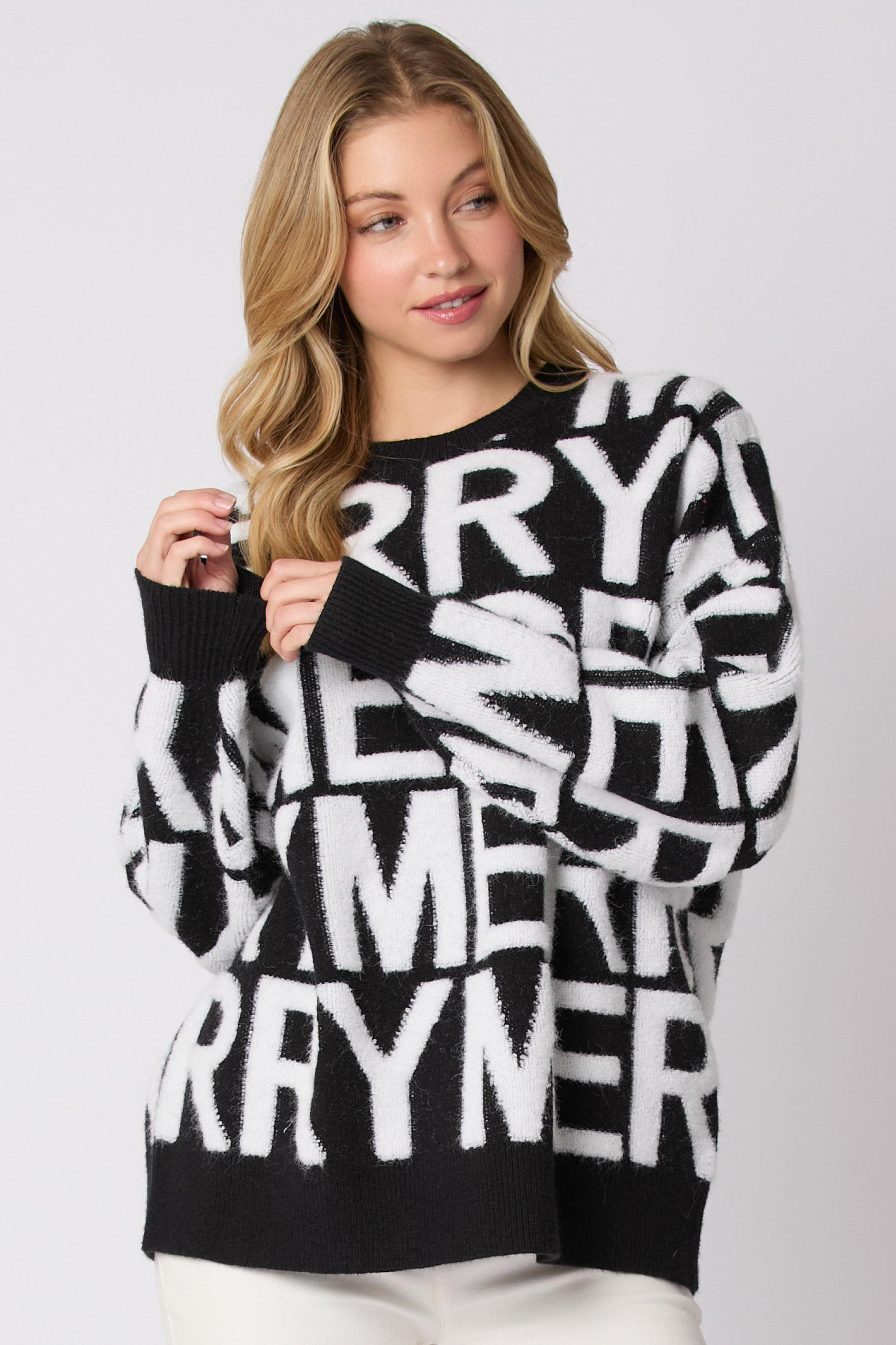 Black and white loose knit long-sleeve pullover sweater with oversized letter graphic