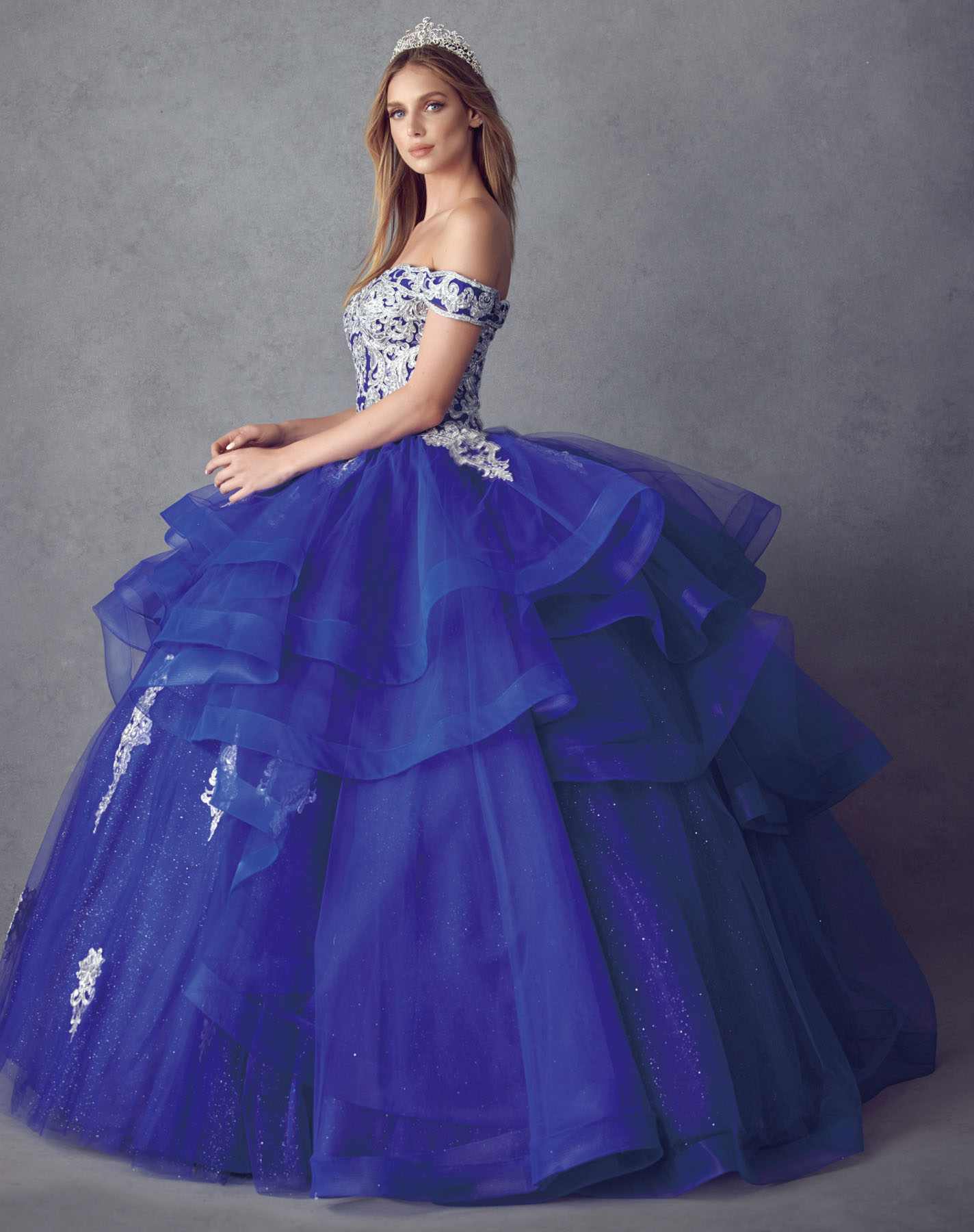 Deep blue off-shoulder ball gown with layered tulle ruffles and sparkling lace trim