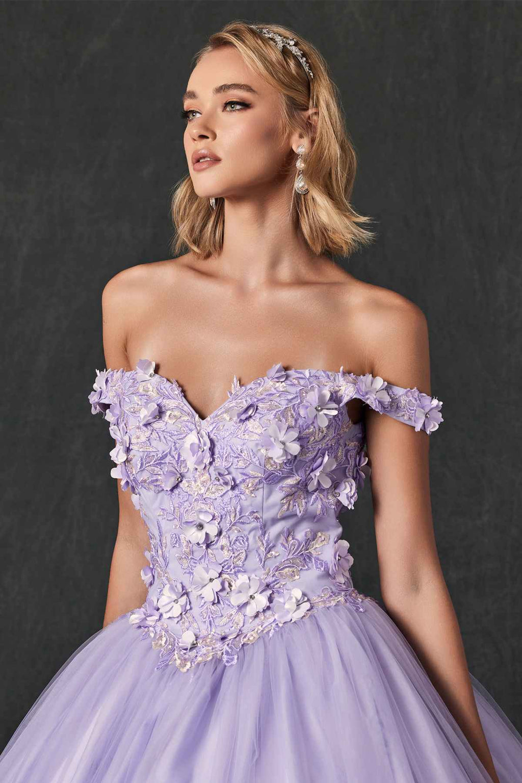 Lilac quinceanera ball gown close-up with off-shoulder ruffled bodice and 3D floral appliques