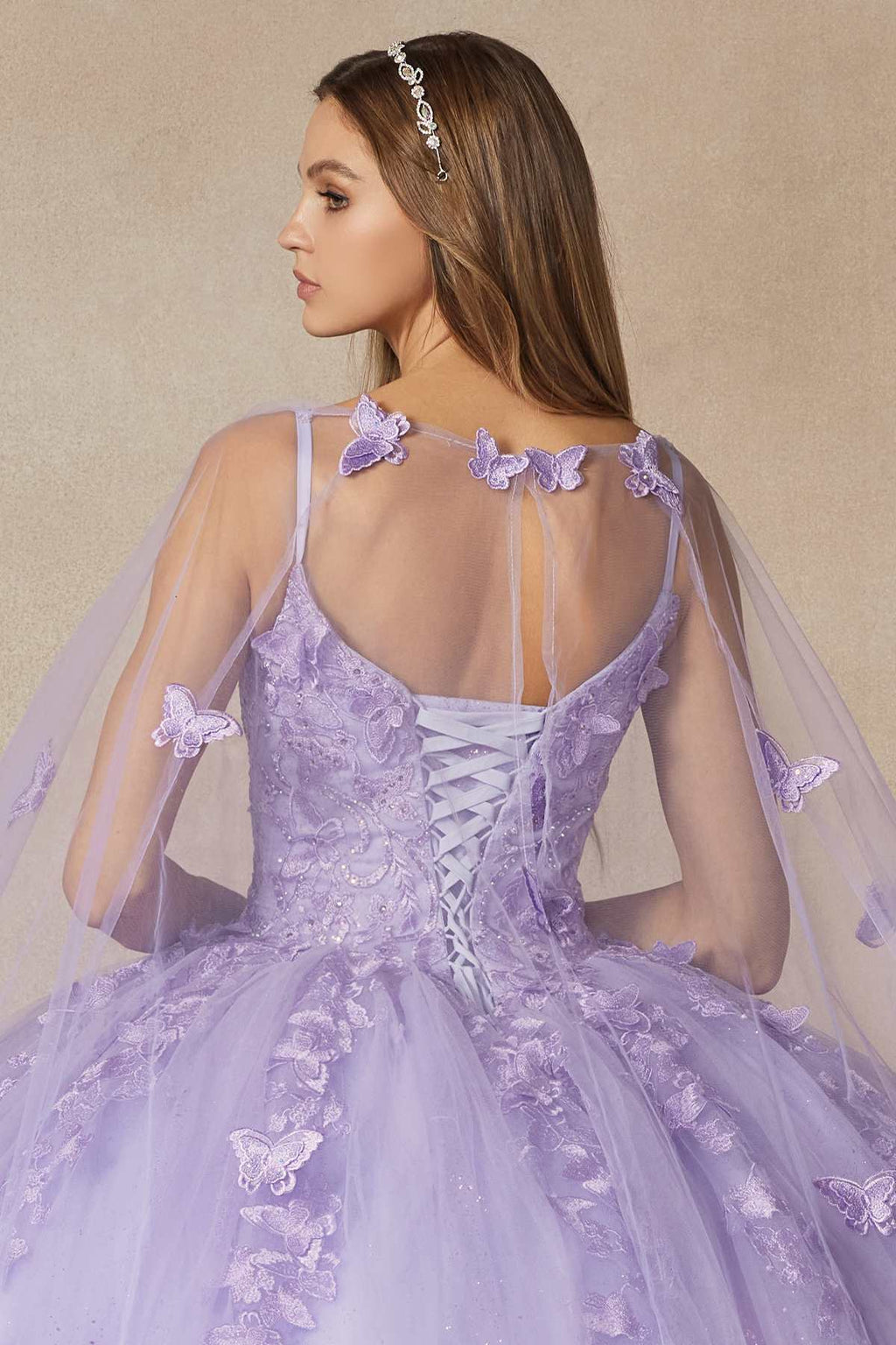 Lilac quinceanera dress back view with lace-up straps, butterfly appliques, sheer cape