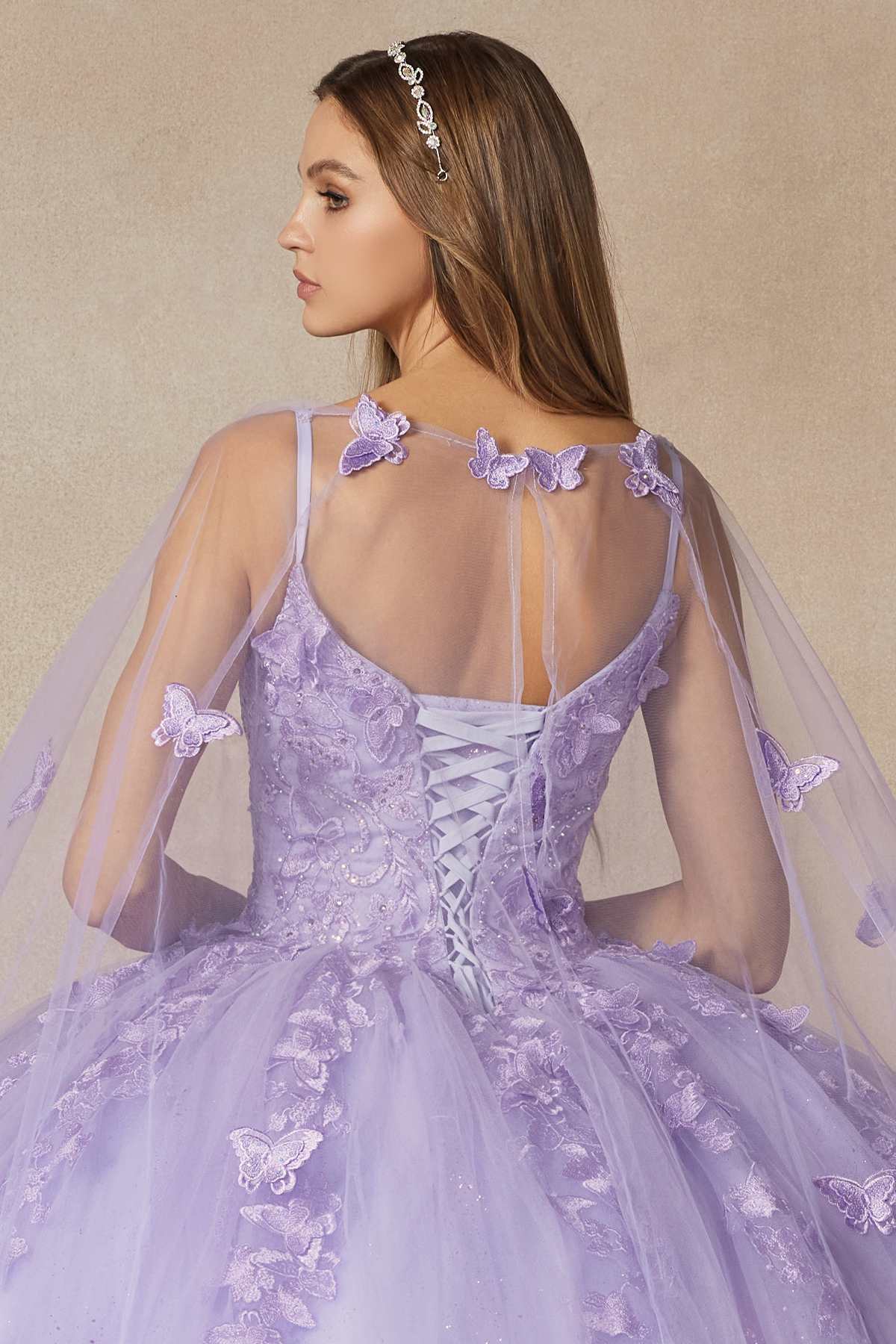 Lilac quinceanera dress back view with lace-up straps, butterfly appliques, sheer cape