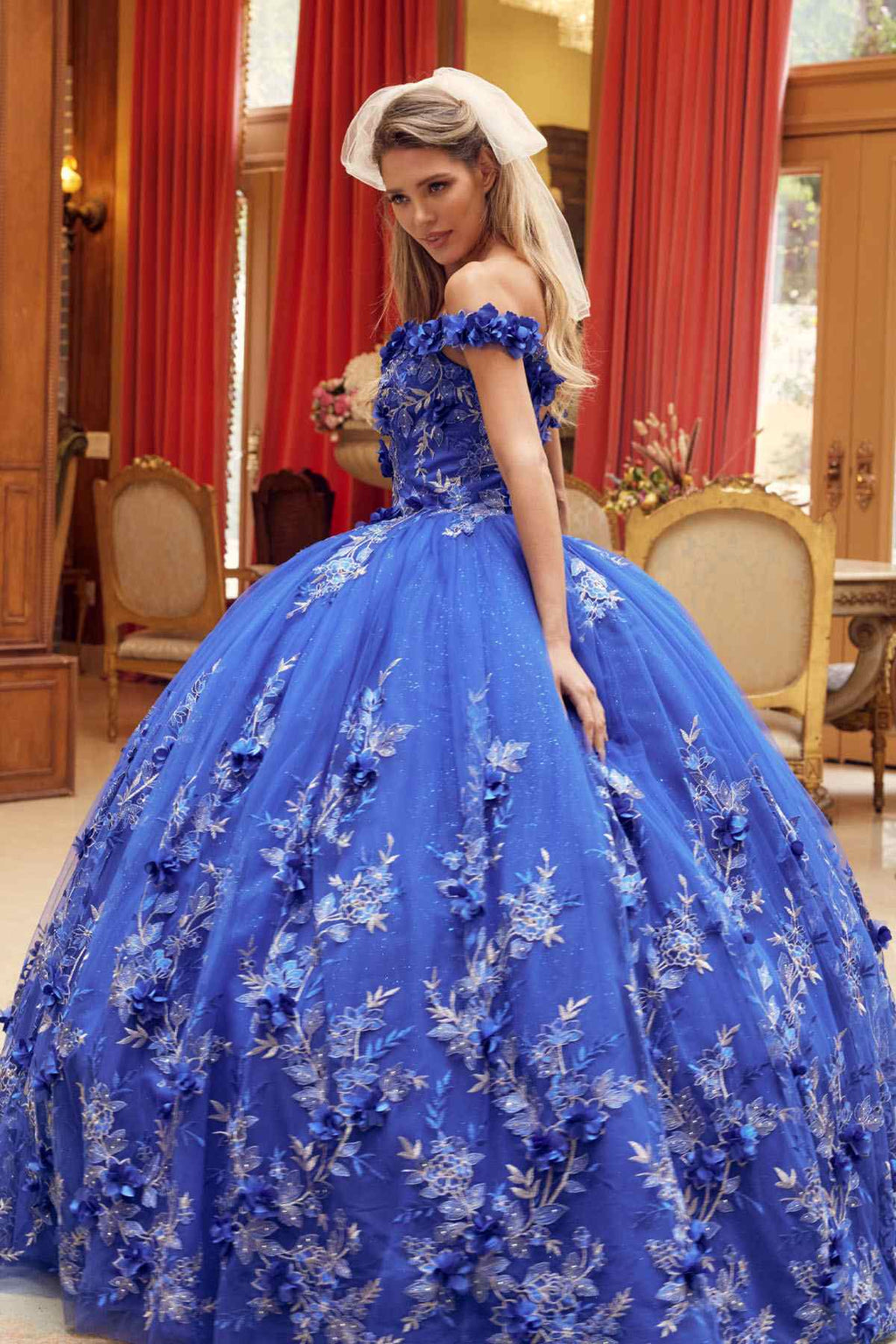 Blue ball gown with off-shoulder neckline and tiered skirt covered in floral appliques