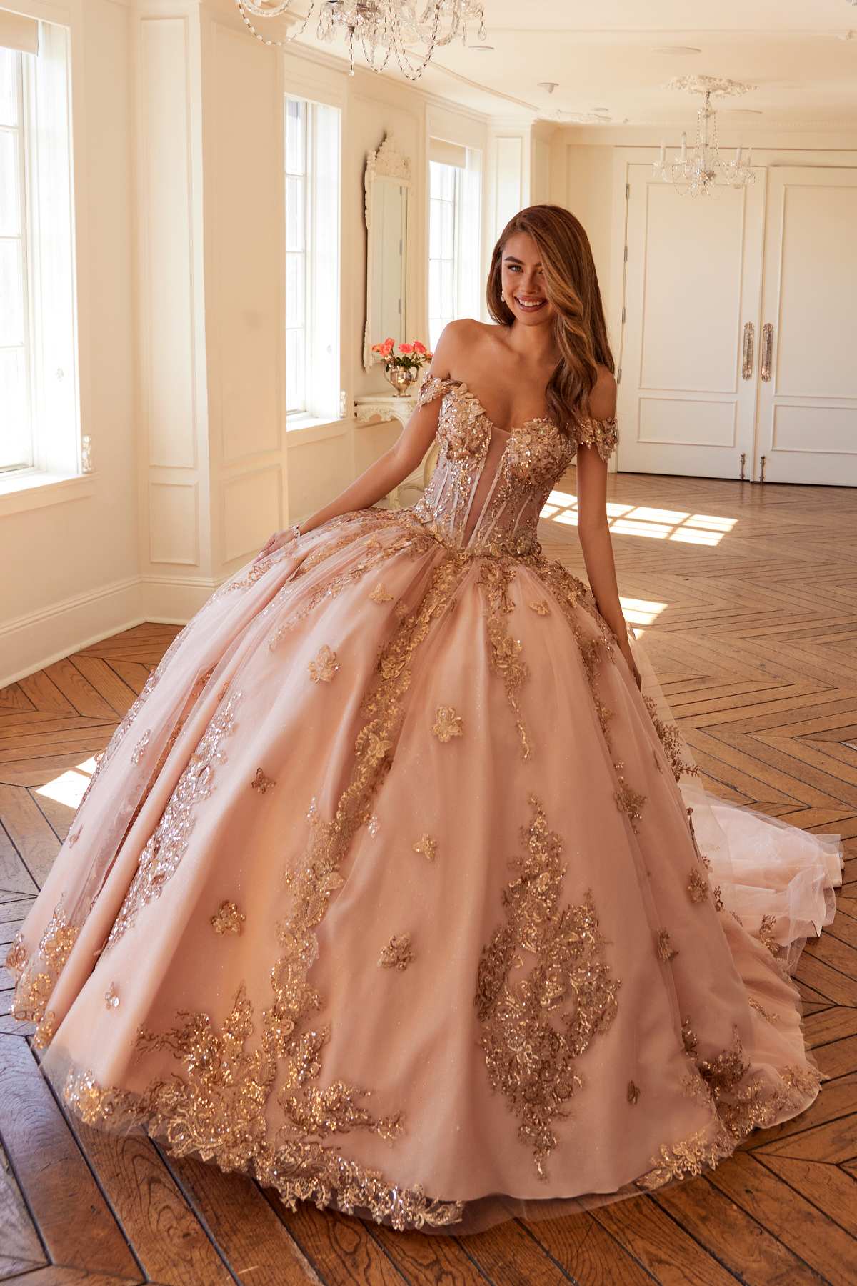 Off-shoulder blush pink ball gown with rose-gold floral embroidery and flared skirt
