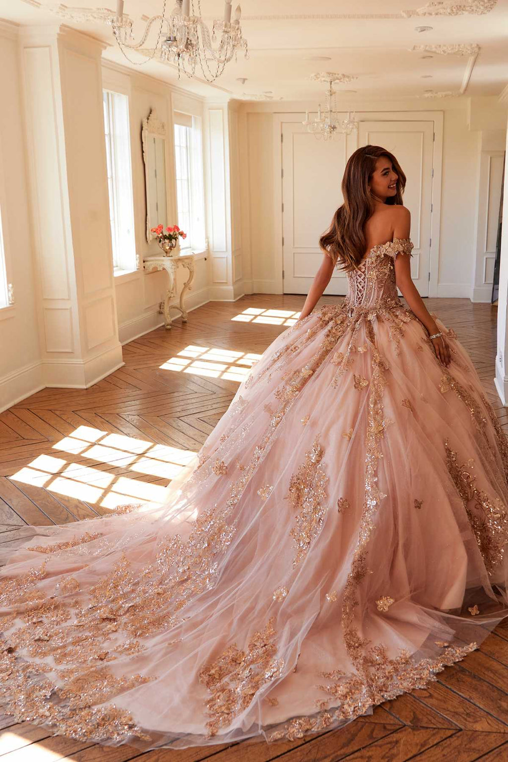 Off-shoulder blush pink ball gown with rose-gold embroidery and flowing skirt train
