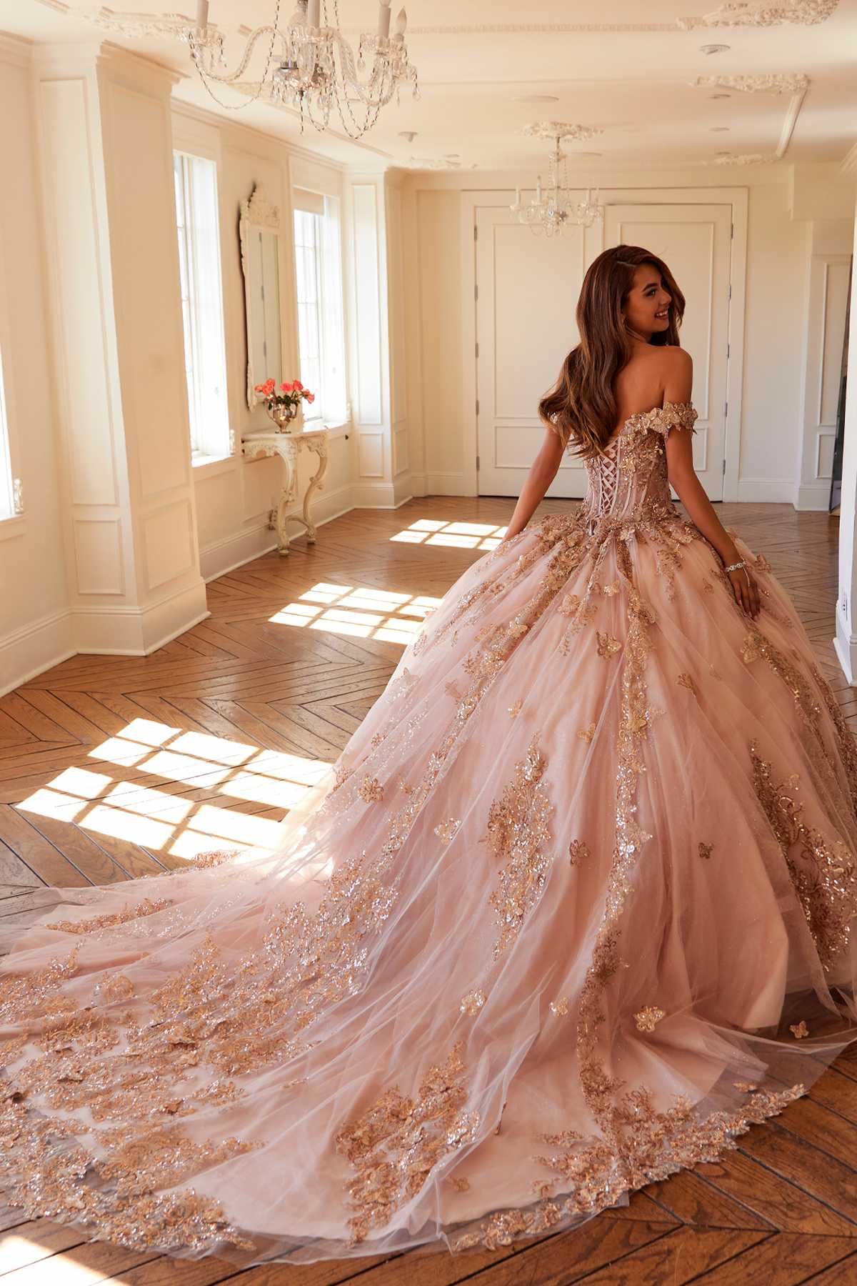 Off-shoulder blush pink ball gown with rose-gold embroidery and flowing skirt train