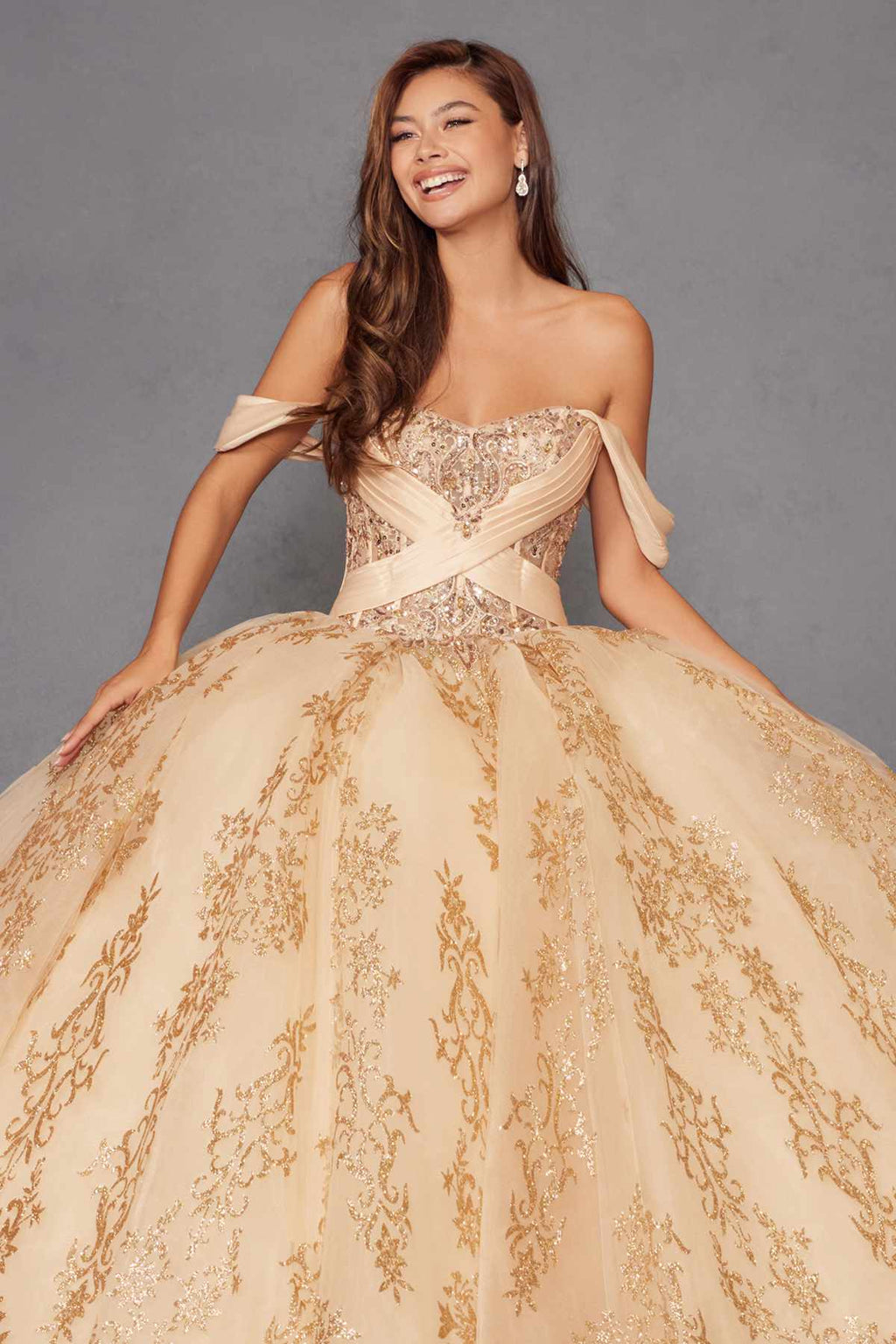 Gold ball gown with sweetheart neckline, off-shoulder sleeves, and embroidered full skirt.
