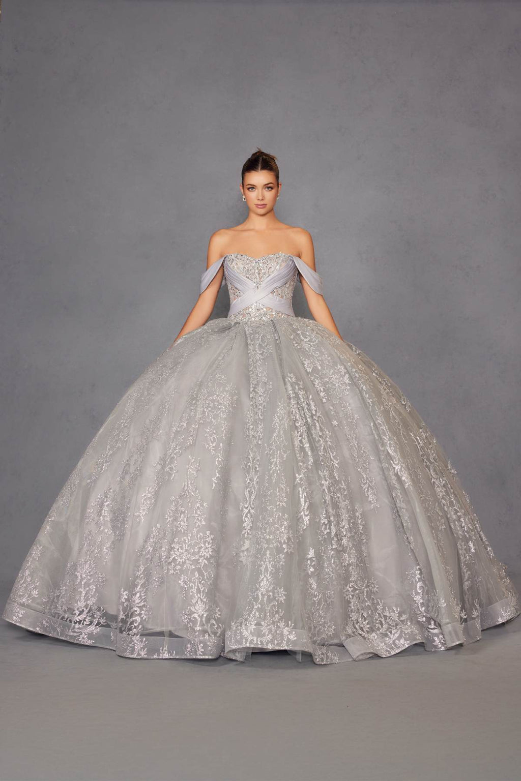 Silver ball gown with sweetheart bodice, off-shoulder sleeves, and full embroidered skirt.