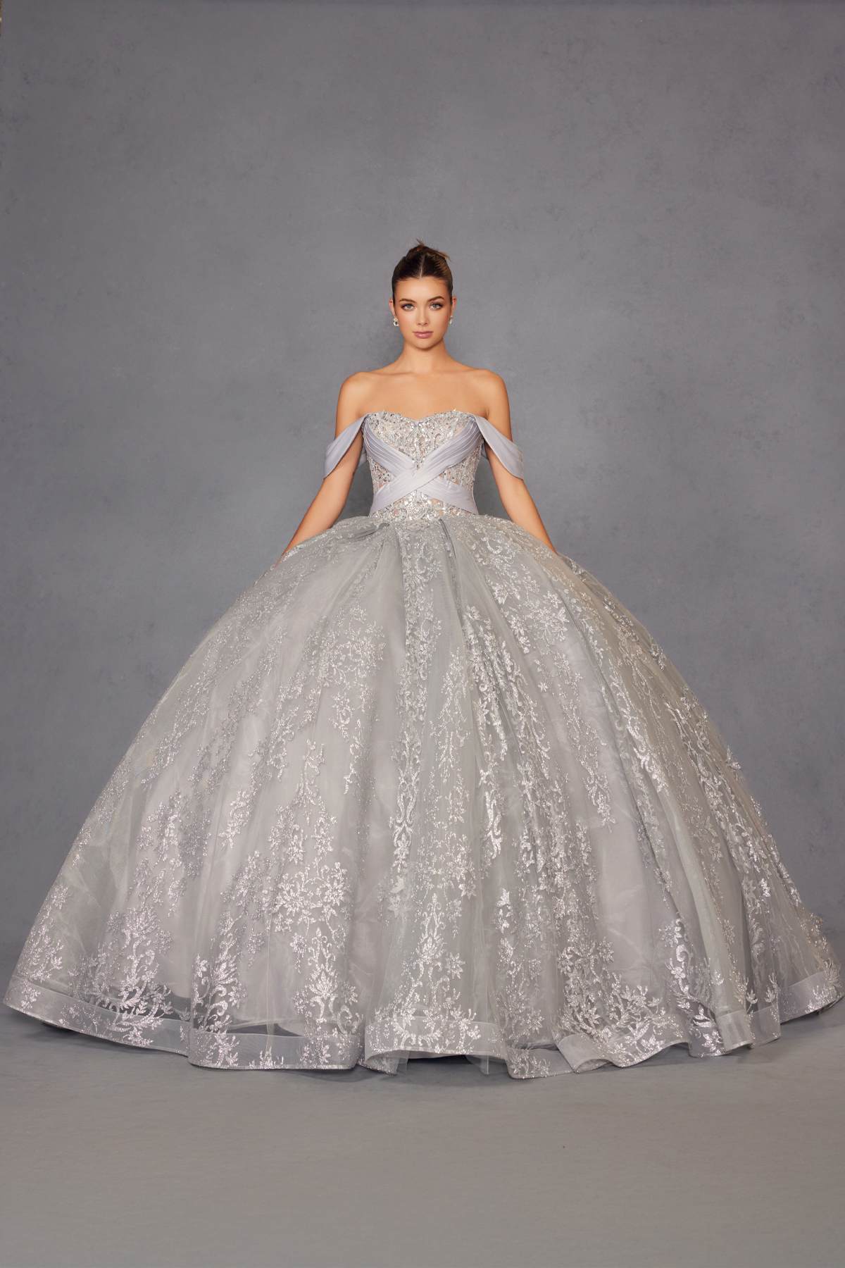 Silver ball gown with sweetheart bodice, off-shoulder sleeves, and full embroidered skirt.