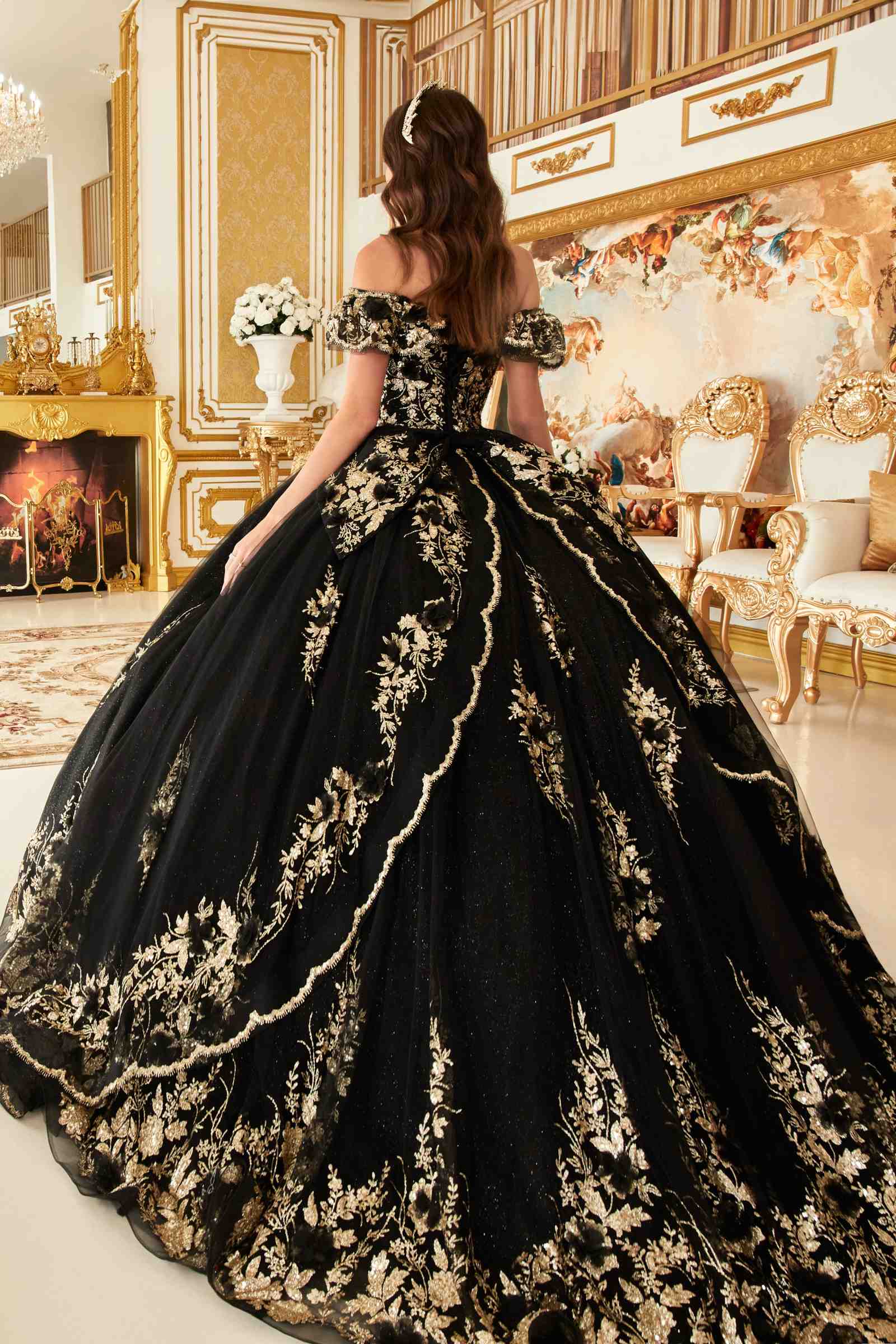Black off-the-shoulder A-line ball gown from the back with gold floral embroidery and lace trim