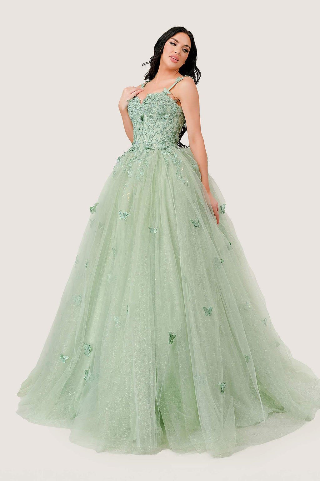 Sage green tulle ball gown with spaghetti straps, floral appliques, and full layered skirt