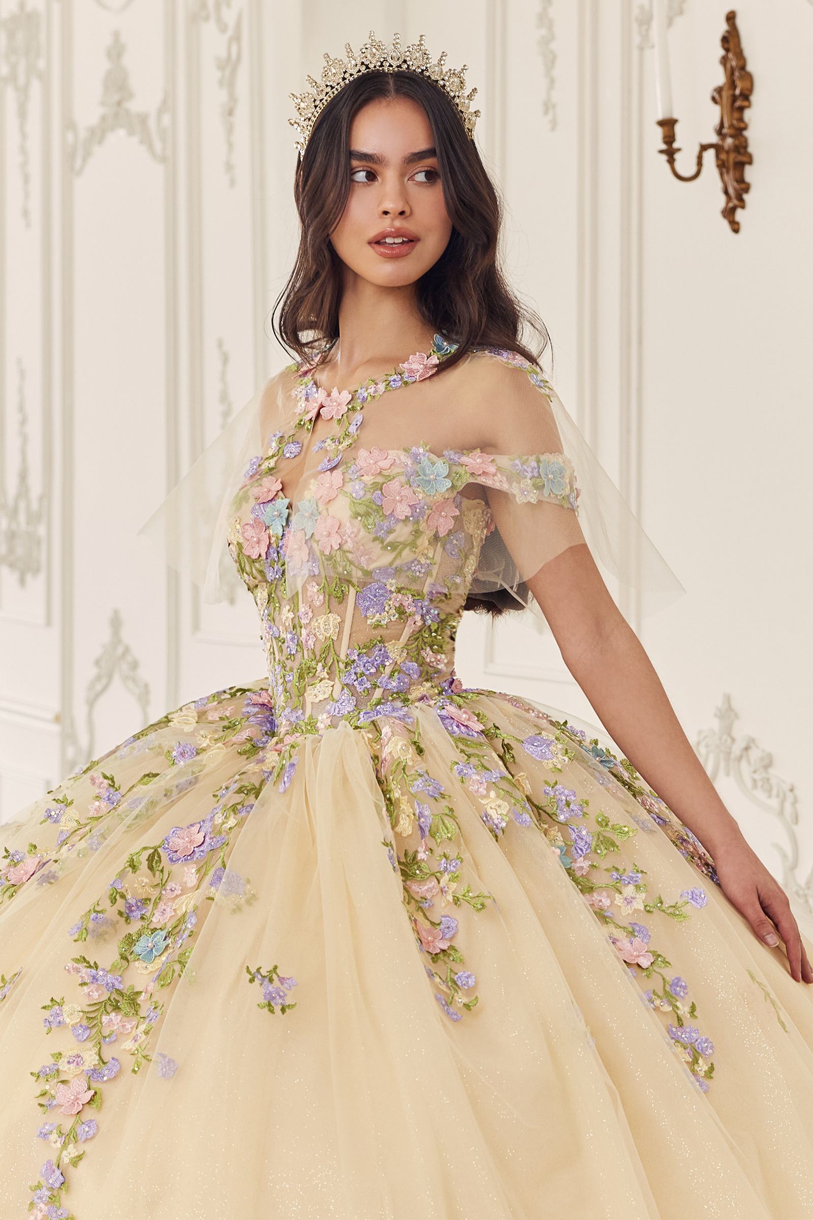 Champagne off-shoulder ball gown with layered skirt and lilac floral appliqué cluster