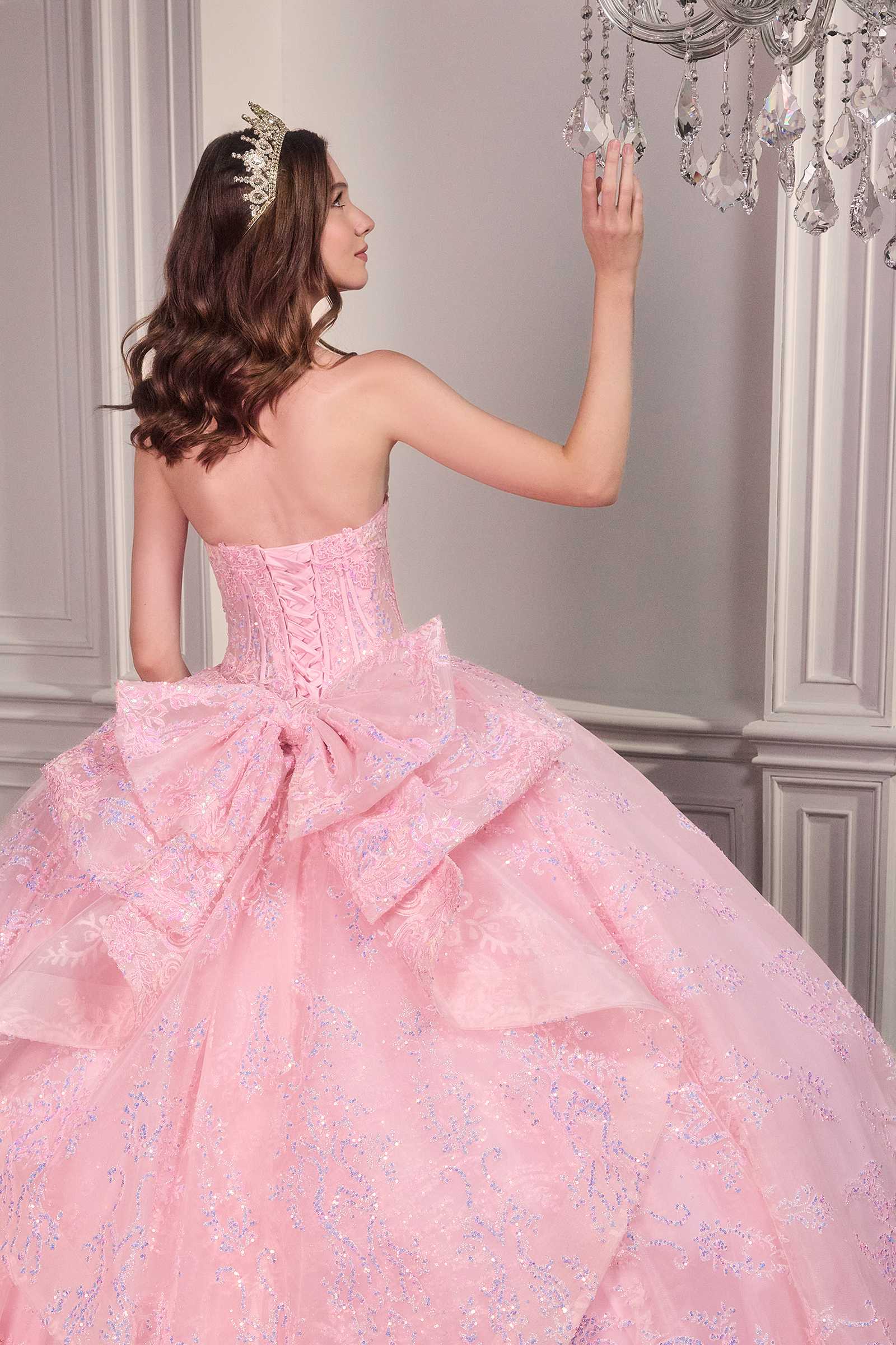 Pink strapless sweetheart ball gown with open corset back and voluminous layered skirt.
